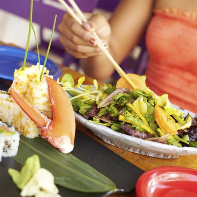 Colse Up Of Mixed Race Woman Enjoying Meal At Restaurant