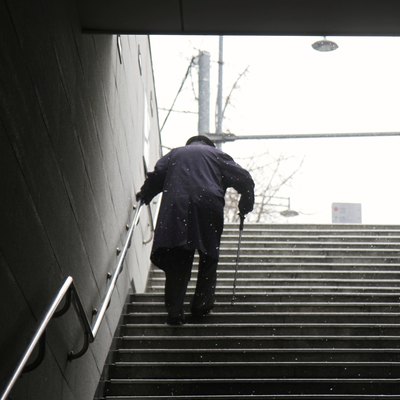 Elderly Man walking up a set of stairs during winter
