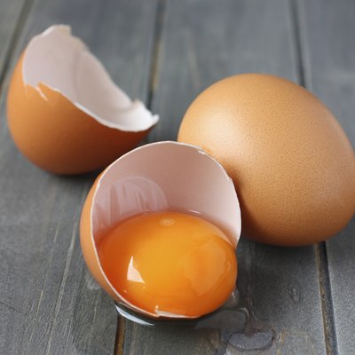 Broken fresh egg on rustic wooden background