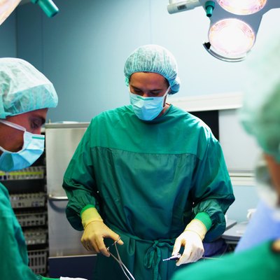 Operating theatre team tending to patient, surgeon operating