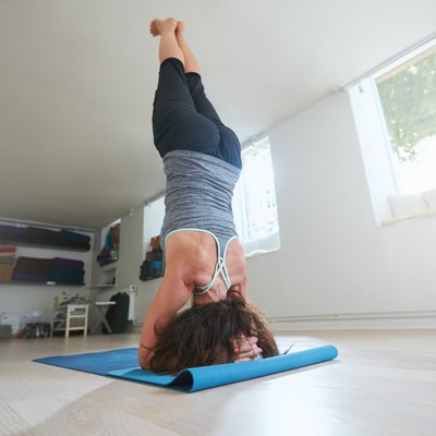 Fitness female practicing Salamba Sirsasana pose