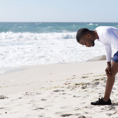 Sports man exhausted after work out with hands on knees