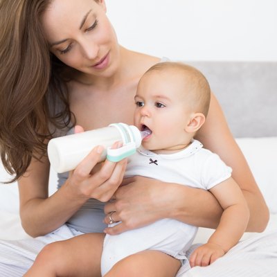 Mother feeding baby with milk bottle