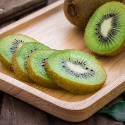 Kiwi fruit slices on wooden plate