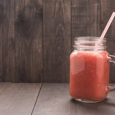 Healthy vegetable. Glass of red tomato juice on wooden table