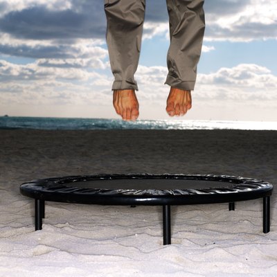 a pair of legs jumping on a trampoline
