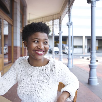 Smiling african american woman sitting at outdoor restaurant