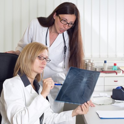 Female Doctors Consulting About Patient's X-ray in Consulting Room