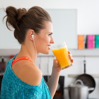 Closeup of fit woman in profile starting to drink smoothie