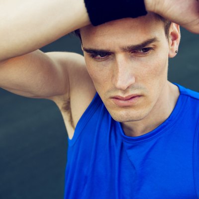 Tired athlete wipes the sweat from his forehead