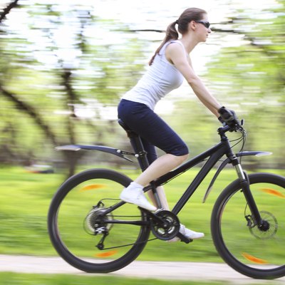 Image of woman riding bicycle in a green park