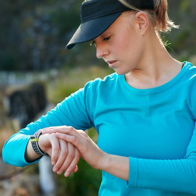 Fit, caucasian woman checking the time during a training run