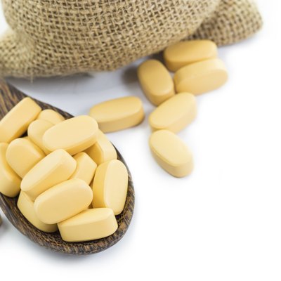 Yellow pills in Empty burlap sack and on spoon