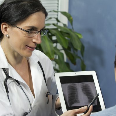 Female doctor showing patient's x-ray with tablet