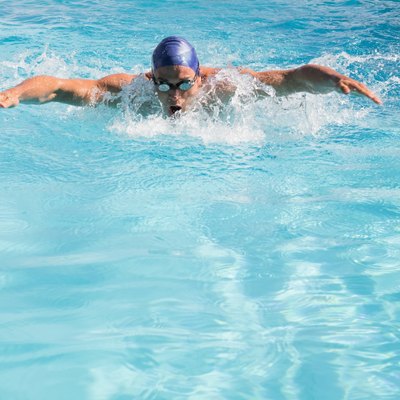 Fit swimmer doing the butterfly stroke in the swimming pool