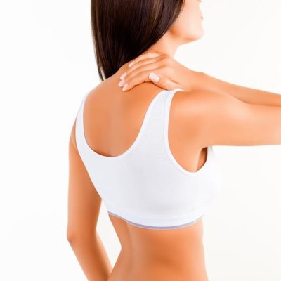 Brunette woman massaging her neck because it hurts