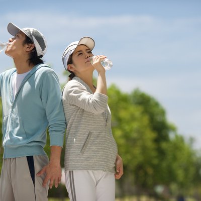 Couple drinking from water bottles