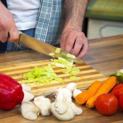 Close-up of man chopping fresh celery.