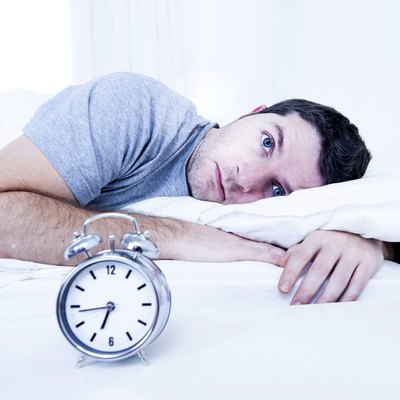 man in bed suffering insomnia and sleeping disorder
