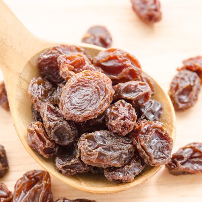 Raisin in wooden spoon.