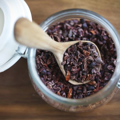 Cacao nibs or raw cocoa beans crushed in a jar