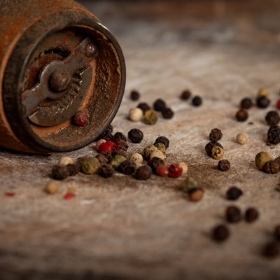 Spice and pepper grinder on wooden background
