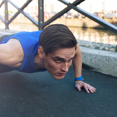 Picture of young handsome athletic man doing pushups