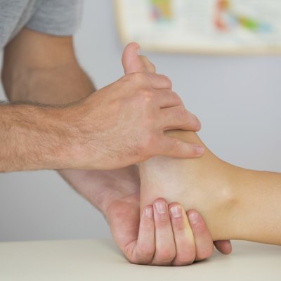 Physiotherapist controlling patients foot