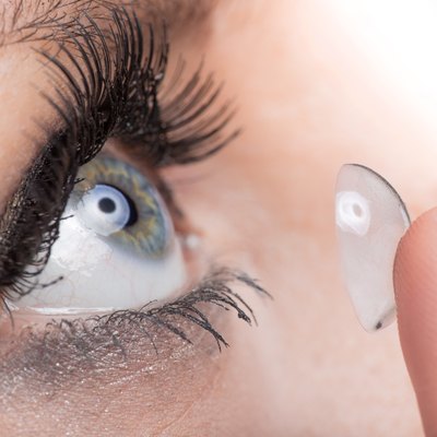 Young woman Inserting a contact lens