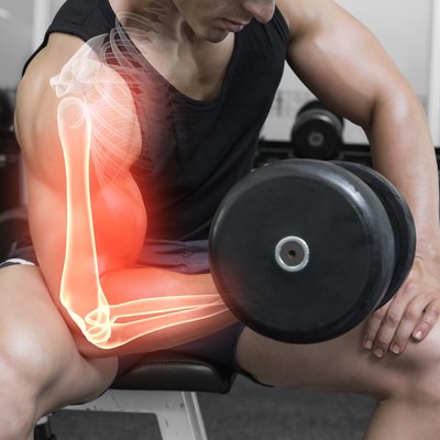 Highlighted arm of strong man lifting weights