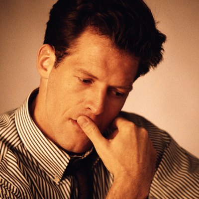 Businessman looking down with finger on lips