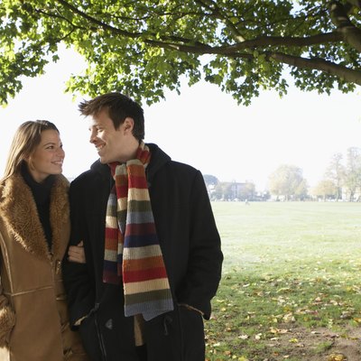Couple walking in park, smiling, autumn