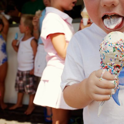 Boy (3-5) eating ice cream, close-up, other children in background