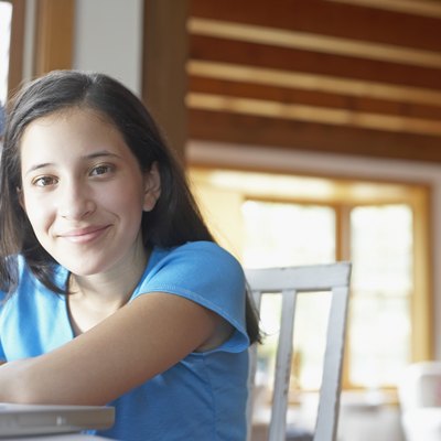 Portrait of a teenage girl leaning on a laptop