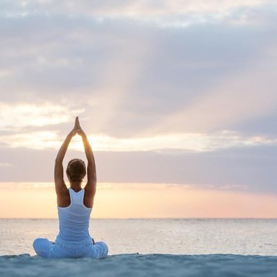 Caucasian woman practicing yoga at seashore