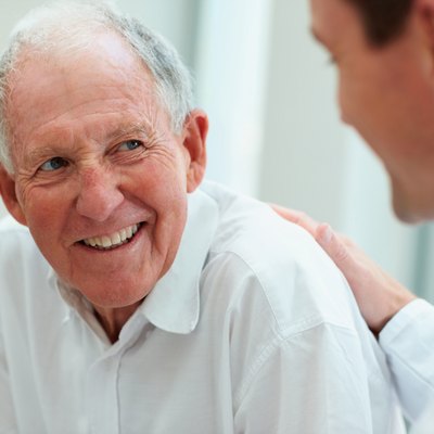 Happy old man having a casual talk with a doctor
