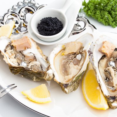 Fresh open oysters on a plate with black caviar