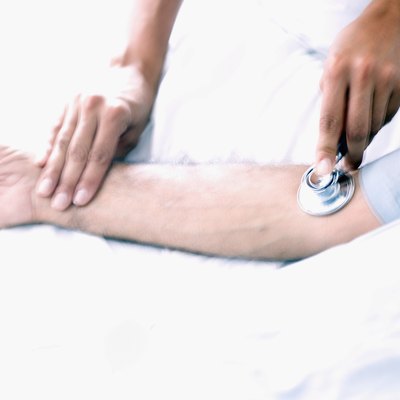 Medical personnel taking a patients blood pressure and pulse