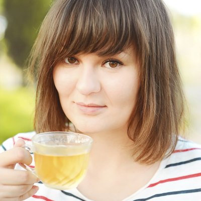 Pretty young woman with tea cup outdoors