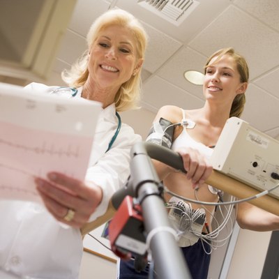 Doctor Monitoring The Heart-Rate Of Patient On A Treadmill