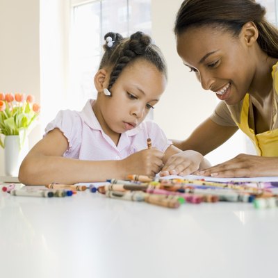 Mother and daughter coloring with crayons