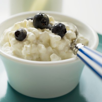 Cottage cheese with blueberries and spoon in a small bowl