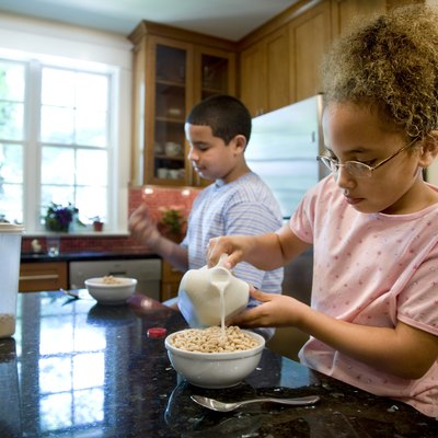 Kids eating cereal in kitchen