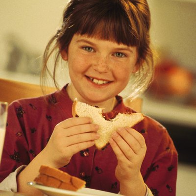 Girl eating a peanut butter and jelly sandwich