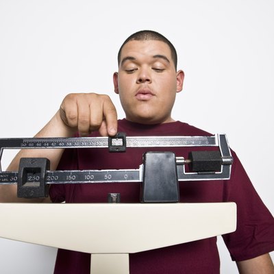 Teenage (16-17) boy using weight scales