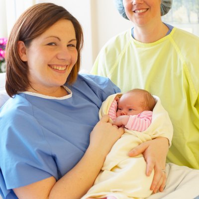 Mother posing with newborn baby and nurse