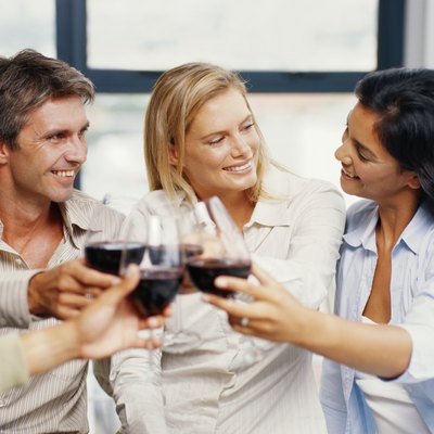 Two young couple toasting red wine in restaurant