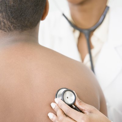 African American female doctor examining boy