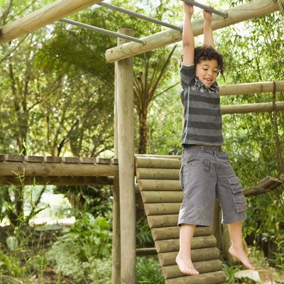 Boy hanging from jungle gym