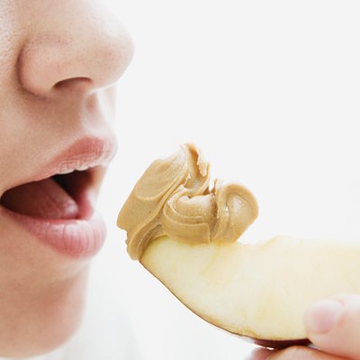 Woman eating apple and peanut butter